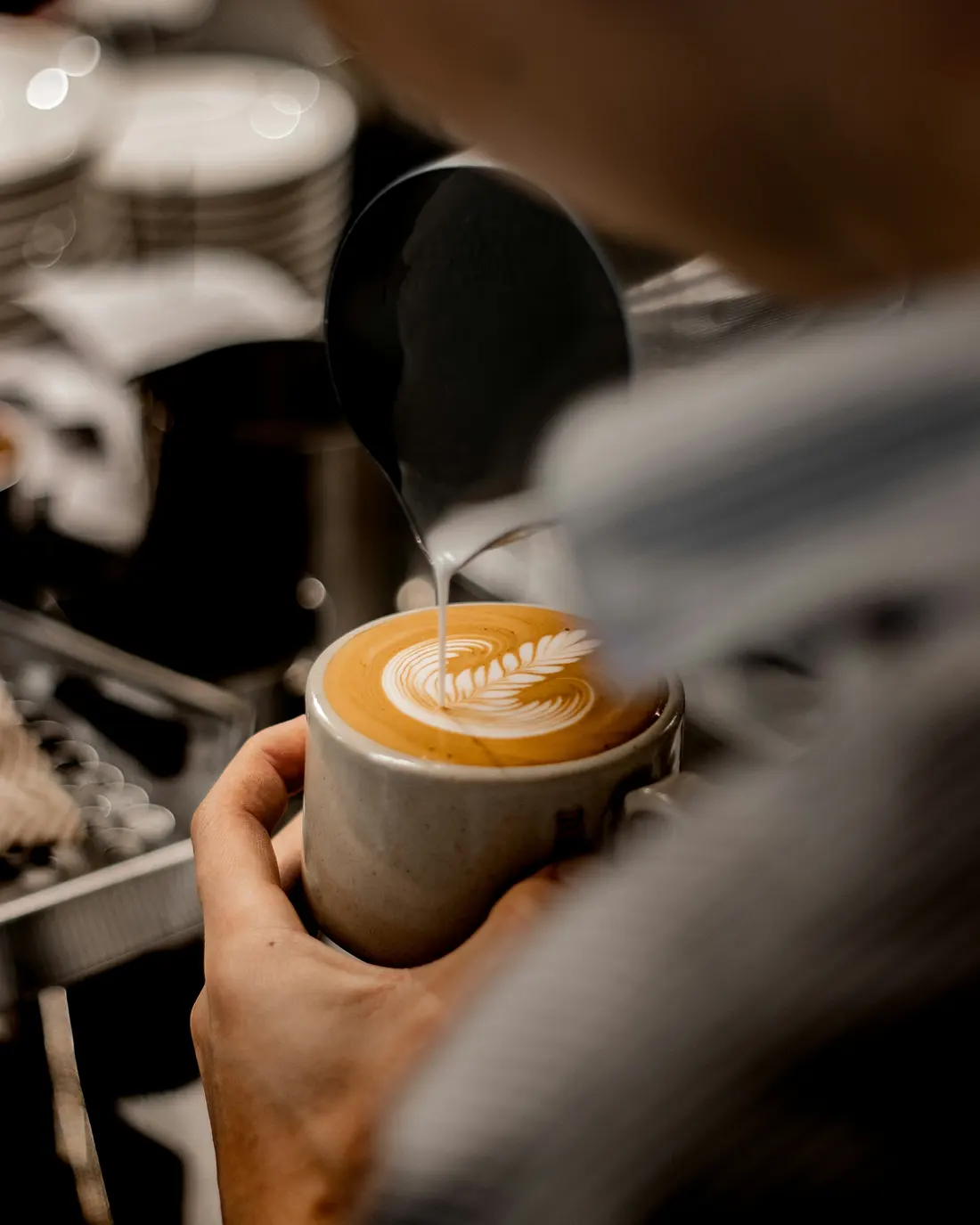 Barista serviert einen Cappuccino mit Latte Art am Messestand