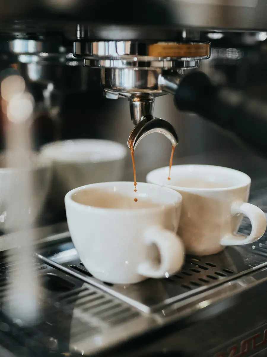 Espresso läuft aus dem Siebträger in zwei Tassen