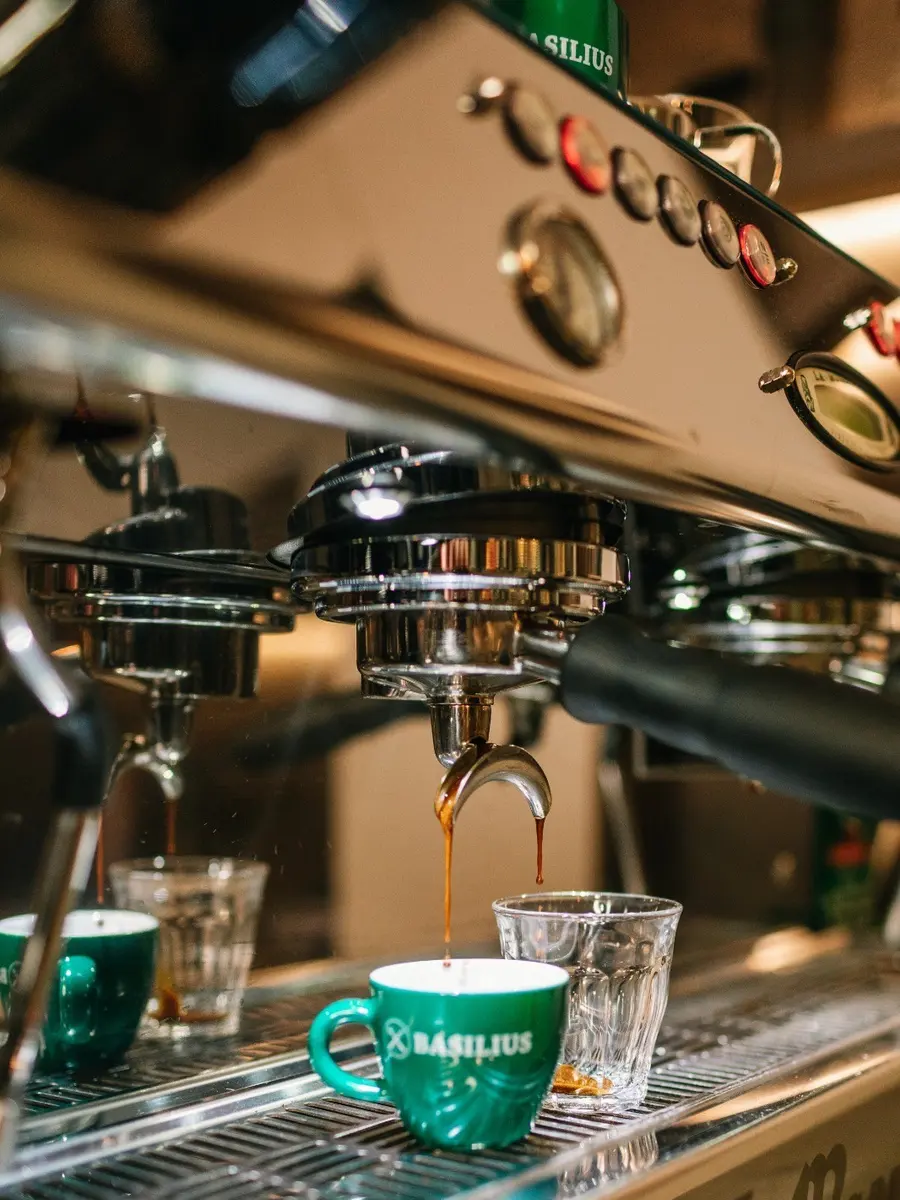 Espresso läuft in grüne Becher an der Siebträgermaschine